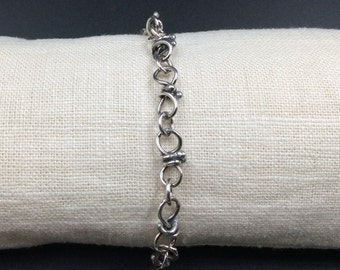 May include: A silver chain bracelet with small beads on each link.