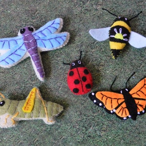 May include: Five felt insect toys: a blue dragonfly, a yellow and black bee, a red ladybug, a green grasshopper, and an orange and black butterfly.
