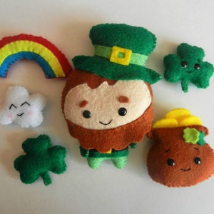 May include: A set of felt ornaments featuring a leprechaun, a rainbow, a cloud, a pot of gold, and shamrocks. The ornaments are all hand-sewn and have a whimsical, cartoonish style.