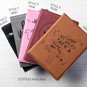 May include: A stack of passport covers in various colors and styles, including black, grey, pink, rose, and rawhide. The covers feature different designs, including a world map, a compass, and a signpost with the words "It's time for a new adventure". The text "12 styles available" is printed below the covers.