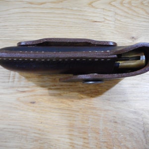 Peut inclure: Un &eacute;tui en cuir marron avec un bord cousu et une fermeture &agrave; pression. L'&eacute;tui est con&ccedil;u pour contenir un couteau de poche.
