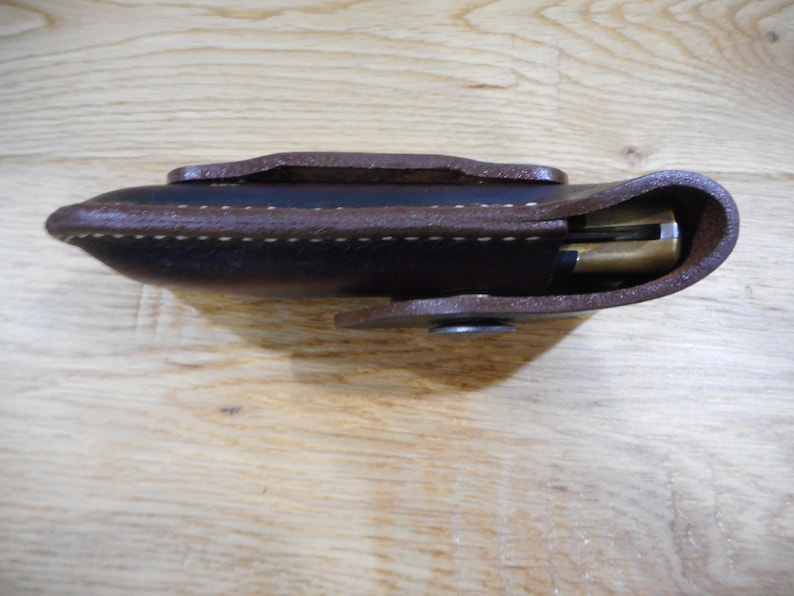 Peut inclure: Un &eacute;tui en cuir marron avec un bord cousu et une fermeture &agrave; pression. L'&eacute;tui est con&ccedil;u pour contenir un couteau de poche.