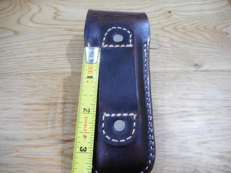 Peut inclure: Un &eacute;tui en cuir marron avec des coutures blanches et deux boutons pression en m&eacute;tal argent&eacute;. L'&eacute;tui mesure environ 7,6 cm de long.