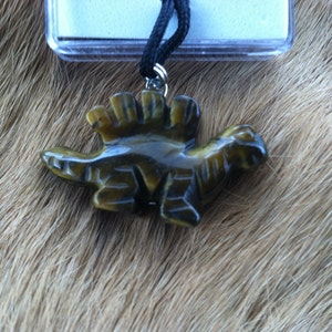 Carved stone dinosaur necklace.  Made of Tiger Eye