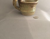 Remuer- Small Mug, Bohemian whirls of brown and light green with unconventional Handle, holds 8 ounces – Made by Blind Ceramic Artist