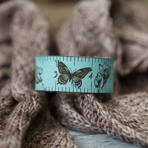 Butterfly and Flowers Leather Ruler Cuff, made from blue leather with bronze stud. Great for measuring knitting, sewing & fiber project