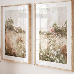 Pode incluir: Duas pinturas de aquarela emolduradas de um campo de flores silvestres com uma mesa consola de madeira com livros e uma cesta de vime por baixo.