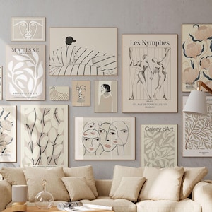 Può includere: Un soggiorno con un divano beige, un tavolino in legno e una collezione di stampe artistiche incorniciate sulla parete. Le stampe presentano disegni astratti e botanici in tonalità neutre. Una lampada da terra e piante in vaso completano l'arredamento.