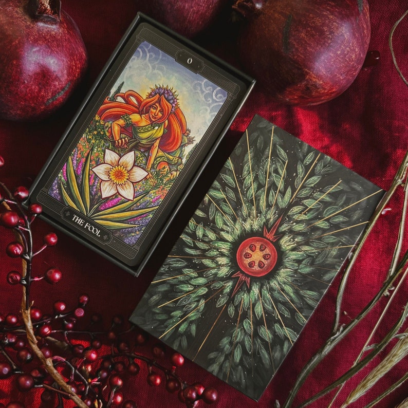 Tarot deck featuring Persephone as The Fool and a pomegranate illustration with gold foil stamping