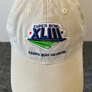 May include: Tan baseball cap with the Super Bowl XLIII logo embroidered on the front. The logo features the words "SUPER BOWL" above the Roman numerals "XLIII" and the text "TAMPA BAY 02.01.09" below the logo.