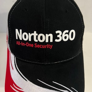 May include: Black baseball cap with a white and red design on the brim. The front of the cap has a white logo that says "Norton 360 All-In-One Security".