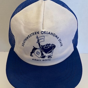 May include: A blue and white trucker hat with a curved brim. The hat features the text "Southwestern Oklahoma State" and "Army ROTC" in navy blue. A bulldog graphic is also present.