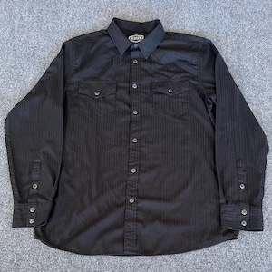 May include: Black long-sleeve button-down shirt with vertical pinstripes. The shirt has two chest pockets, button cuffs, and a collar. The brand name "Riders" is visible on the collar.