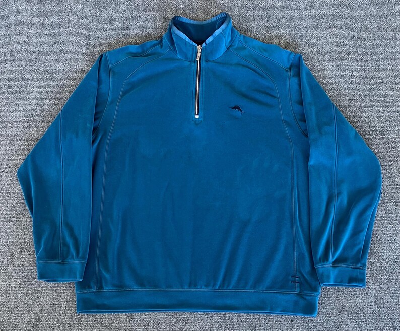 May include: A teal blue 1/4 zip pullover sweater with a small kangaroo logo on the left chest.