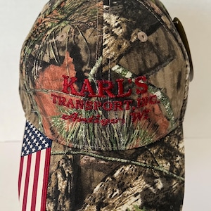 Antigo Wisconsin Hat NWT “Karl’s Transport” Mossy Oak Camo Flag image 1