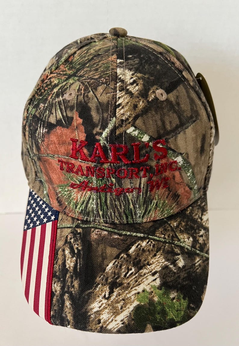 Antigo Wisconsin Hat NWT “Karl’s Transport” Mossy Oak Camo Flag image 1