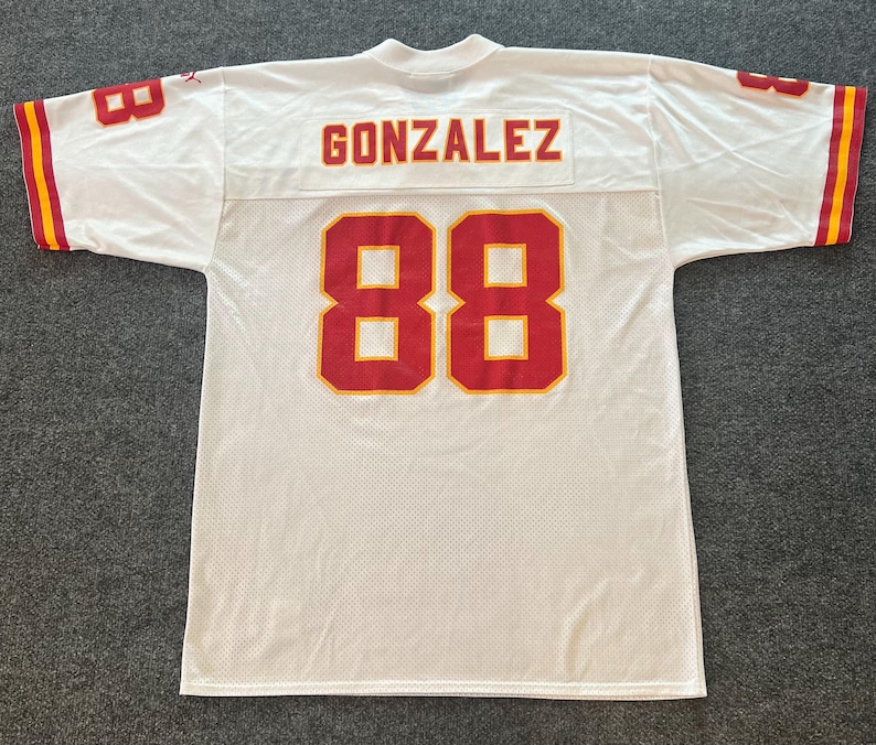 Op de afbeelding: Wit mesh sportshirt met rode en gele accenten. Het shirt heeft de naam "GONZALEZ" over de bovenrug en het nummer "88" in rood op de rug en mouwen. De mouwen hebben rood-gele strepen.