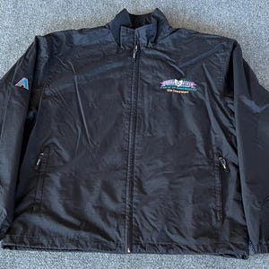 May include: Black windbreaker jacket with a zipper closure and two pockets. The jacket has a logo on the front that says "Great Lakes Classic" and "2010 Championship".