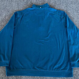 May include: A teal blue long-sleeved pullover sweater with a mock neck collar.