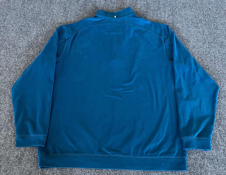 May include: A teal blue long-sleeved pullover sweater with a mock neck collar.