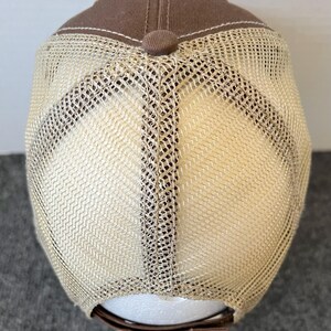 Op de afbeelding: Een bruine truckerpet met een mesh achterkant. De pet heeft een bruine kroon en een beige mesh achterkant. De klep is gebogen en de pet heeft een verstelbare band. De pet is ontworpen voor casual wear.