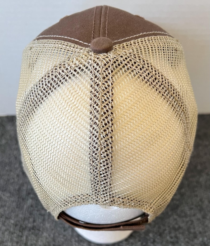 Op de afbeelding: Een bruine truckerpet met een mesh achterkant. De pet heeft een bruine kroon en een beige mesh achterkant. De klep is gebogen en de pet heeft een verstelbare band. De pet is ontworpen voor casual wear.