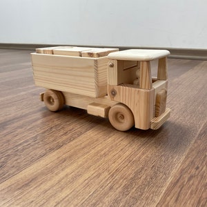 Houten speelgoedvrachtwagen met bouwstenen en een chauffeur met een knijper: houten speelgoed voor kinderen en volwassenen!