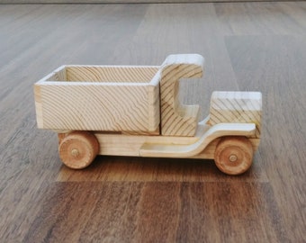 May include: A wooden toy truck with a flatbed and wheels. The truck is made of natural wood and has a simple design.