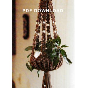May include: A brown macrame plant hanger with white beads and a tassel. The hanger is holding a potted plant with green leaves. The text "PDF DOWNLOAD" is visible in the image.