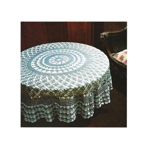 May include: A round, crocheted tablecloth in shades of white and gray covers a table. The intricate design features a central spiral pattern and a scalloped edge. The tablecloth is made of a delicate, open-weave material.