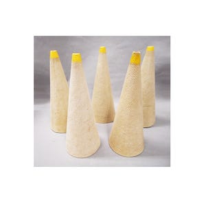 May include: Five tall, conical textile bobbins made of a light beige, textured material. Each cone features a distinct, bright yellow painted tip at the narrow top end. The bobbins are arranged in a cluster, standing upright with a wide base.