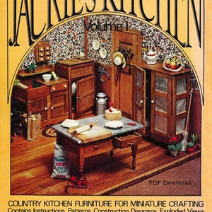 Może przedstawiać: Miniaturowa scena kuchenna z drewnianymi meblami, w tym szafkami, stołem i powierzchnią roboczą. Scena osadzona jest na tle tapety w kwiaty. Tekst "JACKIE'S KITCHEN" jest wyświetlany u góry, z dodatkowym tekstem wskazującym instrukcje dotyczące tworzenia miniatur.