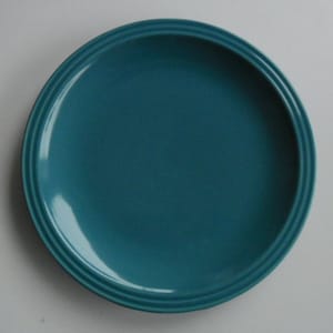 Puede incluir: Un plato de cerámica azul turquesa con un borde ligeramente elevado.