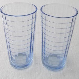 May include: Two clear blue glass drinking glasses with a ribbed design.