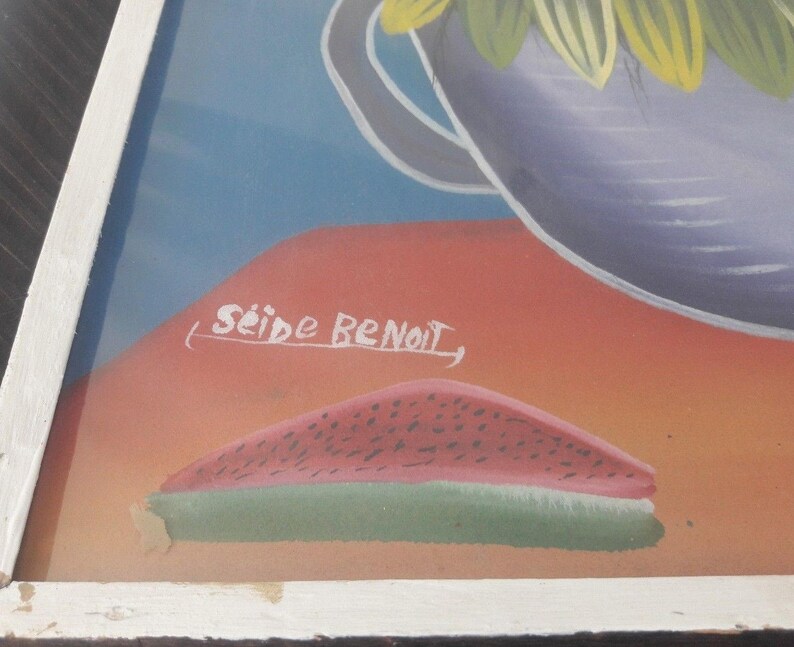 May include: A framed painting of a watermelon slice on a red and orange background. The painting is signed "Seide Benoit".