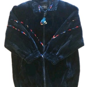May include: A dark navy blue faux fur jacket with a zip closure. The jacket features colorful braided trim on the collar and sleeves, and a matching tassel on the zipper. The label reads "Made in Italy".