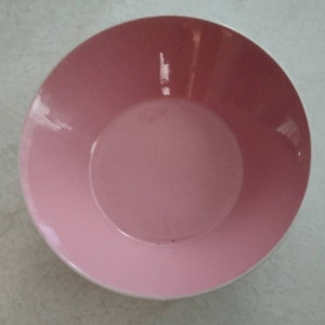 May include: A large, pink ceramic bowl with a smooth, glossy finish. The bowl is empty and ready to be used.