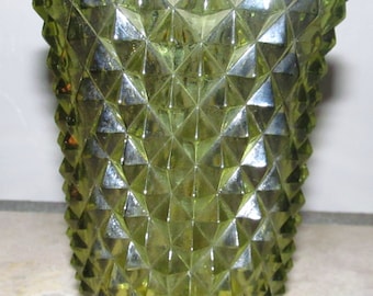 May include: A green glass vase with a diamond pattern. The vase has a wide mouth and a narrow base.