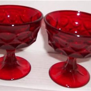 Può includere: Due coppette da dessert in vetro rosso con un motivo a diamante.