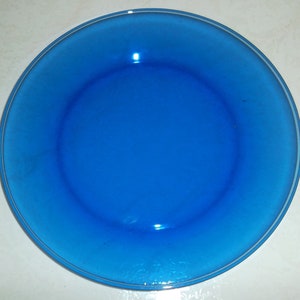 Puede incluir: Un plato de cena de vidrio azul brillante con un borde ligeramente elevado.