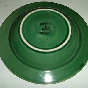May include: The bottom of a green ceramic bowl with the text "Hampton @ Home" and "China" printed on the bottom.