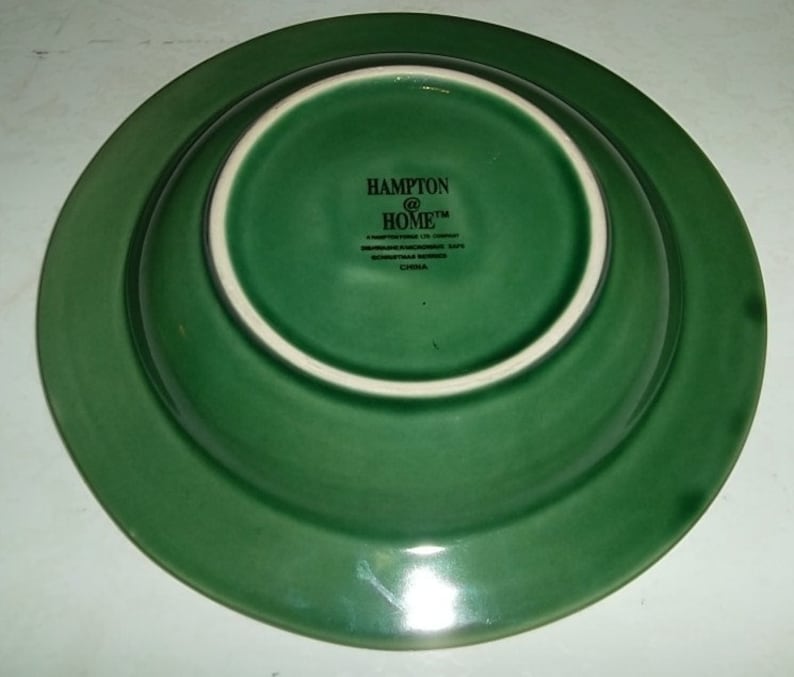 May include: The bottom of a green ceramic bowl with the text "Hampton @ Home" and "China" printed on the bottom.
