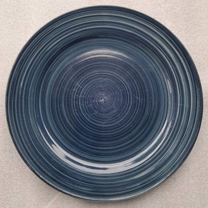May include: A blue ceramic dinner plate with a swirling pattern.