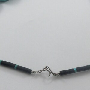 May include: A turquoise and black beaded necklace with a silver clasp.