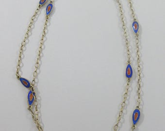 Puede incluir: Un collar de cadena de oro de doble cadena con colgantes en forma de lágrima de esmalte azul y naranja.