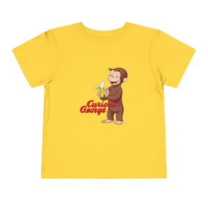 Curious George Peeling a Banana Modern Cartoon with Logo Toddler Unisex Bella+Canvas Short Sleeve Tee