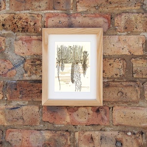 May include: A framed illustration of a group of plants with their roots showing. The plants are drawn in shades of brown and beige against a light yellow background.