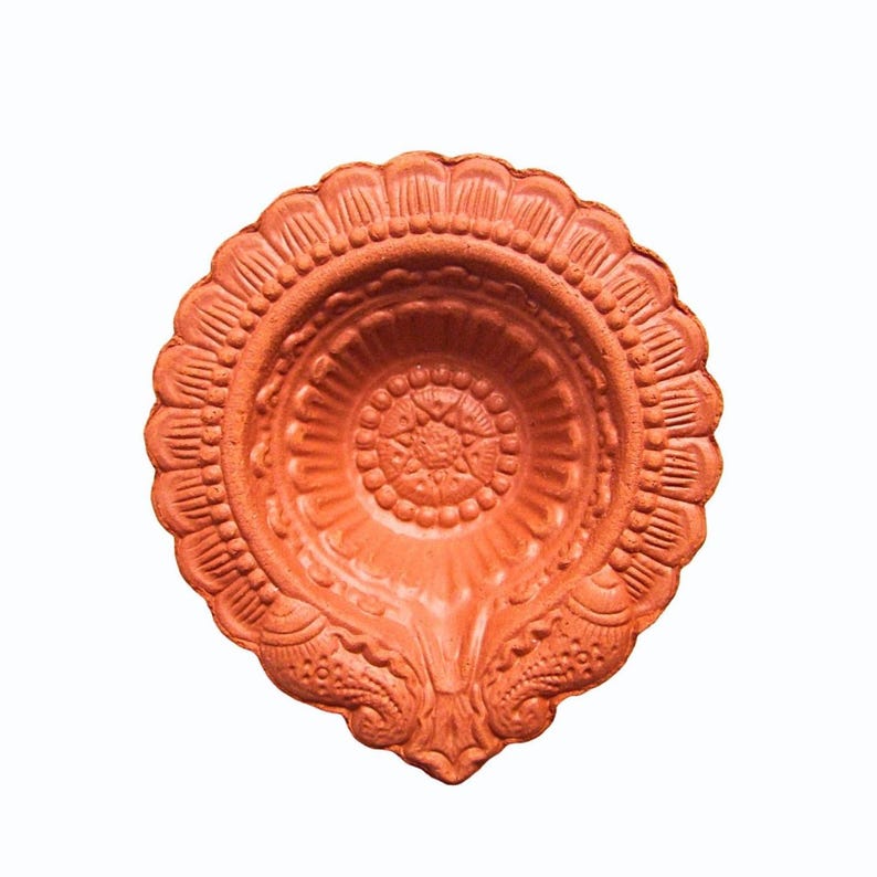 Round terracotta diya lamp with intricate floral design. The diya is a traditional Indian lamp used during Diwali and other festivals. Authentic handcrafted clay diya by Store Utsav. Global shipping.