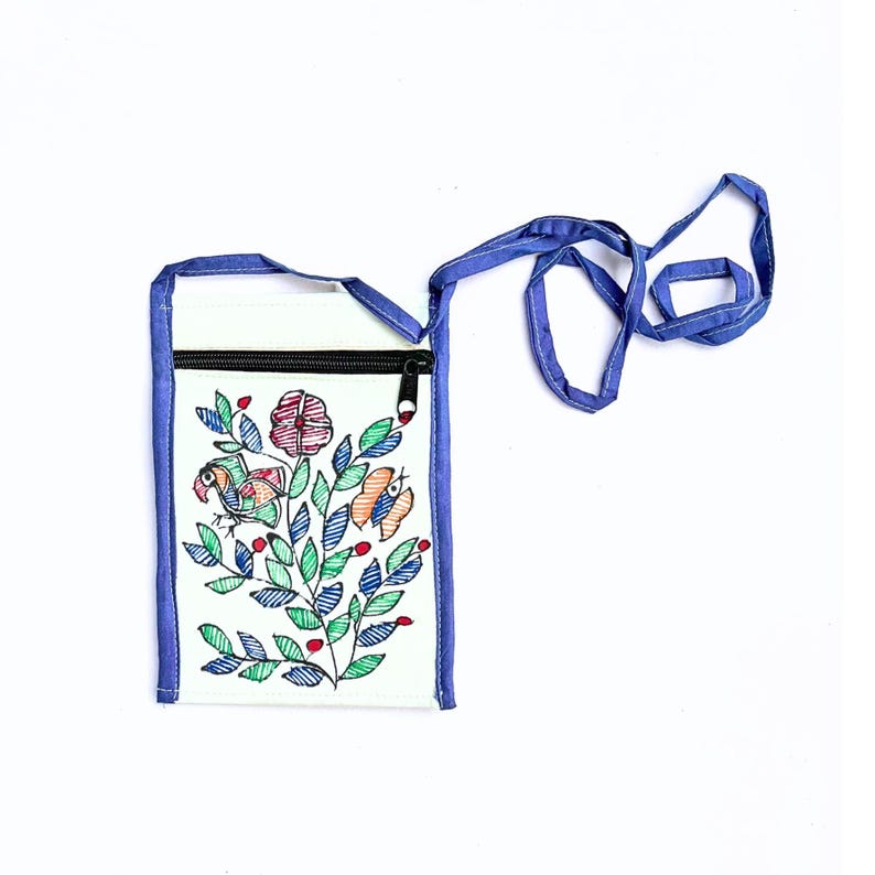Front view of a mint upcycled cotton zippered pouch with a blue trim extending to form a long blue strap by Store Utsav. The pouch has Madhubani painting done. Its a floral design with green leaves, red flowers, and orange and blue birds. The pouch is a great way to carry your phone, keys, or other small items. Global shipping!