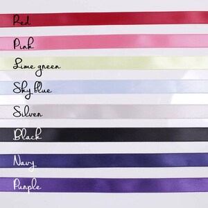 Pu&ograve; includere: Una collezione di nastri di raso colorati in varie tonalit&agrave;, tra cui rosso, rosa, verde lime, celeste, argento, nero, blu navy e viola. Ogni nastro &egrave; etichettato con il nome del colore corrispondente in corsivo.